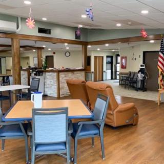 A cozy community lounge area with tables, chairs, and patriotic decorations.