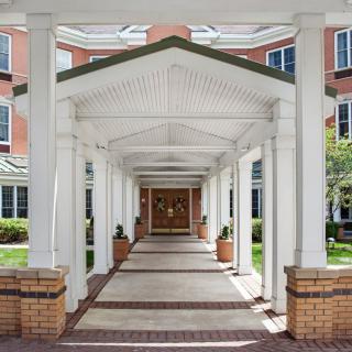 A covered walkway leading to the entrance of a building with columns on either side.