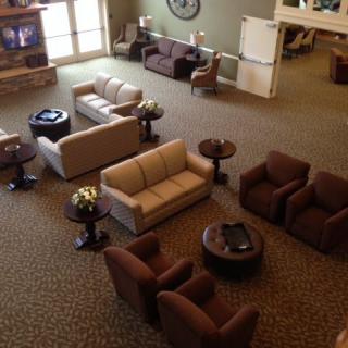 A cozy lobby area with sofas, chairs, and tables arranged for comfort.