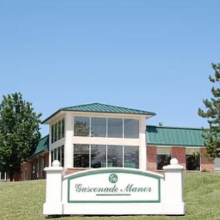 A commercial building featuring a welcoming sign and surrounded by greenery.