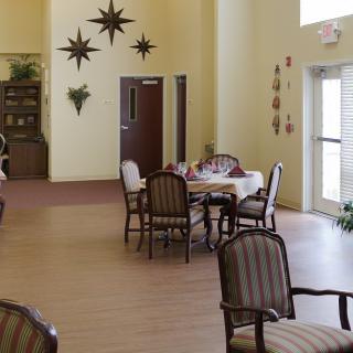 A cozy dining area with tables and chairs, adorned with wall decorations and plants.