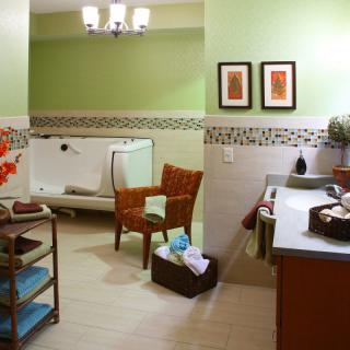 A modern bathroom with green walls, featuring a bathtub, chair, and stylish decor.