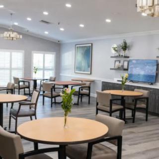 A modern dining area with round tables, comfortable chairs, and elegant lighting.