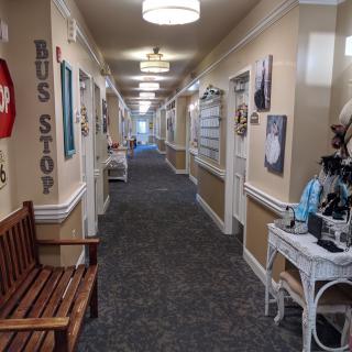 A decorated hallway with benches and various signs along the walls.