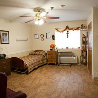 A cozy bedroom featuring a bed, chair, and decorative elements.