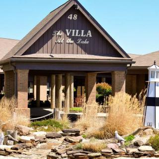 The entrance to The Villa at the Lake, featuring elegant landscaping and a welcoming facade.