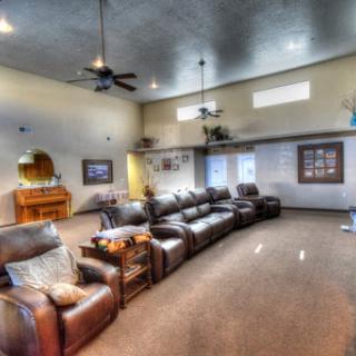 A spacious and modern living room featuring comfortable leather sofas and ample natural light.