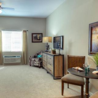 A cozy living room with elegant furniture and decor, featuring a window that lets in natural light.