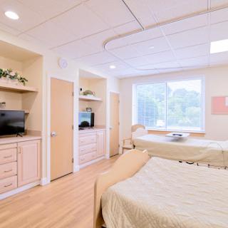 A spacious and modern hospital patient room featuring comfortable beds and a welcoming atmosphere.
