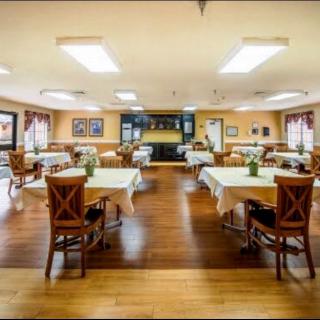 An empty dining room with neatly arranged tables and chairs in a well-lit interior.