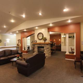 A modern living room with a comfortable seating area and a stone fireplace.