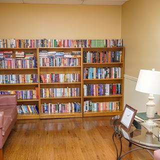 A cozy living room with a well-stocked bookshelf and comfortable seating.