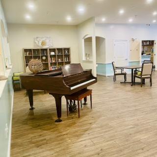 A cozy music room featuring a grand piano and seating arrangements for relaxation.