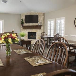 A cozy dining room with a wooden table, chairs, and a fireplace.