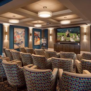 A luxurious home theater with comfortable seating and a large screen.