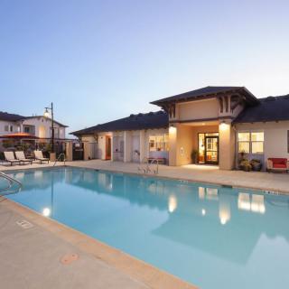 A serene residential swimming pool area at dusk, featuring modern architecture.