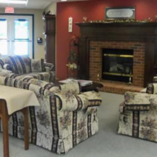 A cozy living room with a patterned sofa set and a brick fireplace.