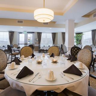 An elegantly set dining area with round tables and classic decor.