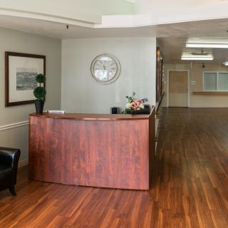 A reception area with a wooden desk and flooring.