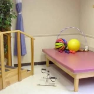 A physical therapy room equipped with exercise equipment and a small staircase for rehabilitation exercises.