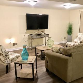 A cozy living room with a mounted TV, comfortable seating, and stylish decor.