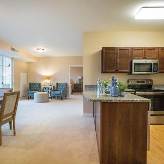 Modern open floor plan apartment with kitchen, dining, and living areas.