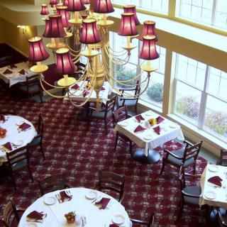 A luxurious restaurant interior with elegant chandeliers and neatly arranged dining tables.