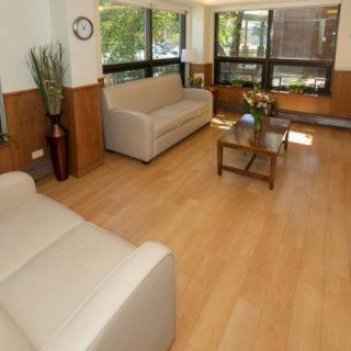 A cozy living room with sofas, a coffee table, and large windows allowing natural light to fill the space.