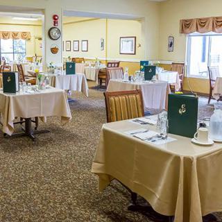 A cozy dining room set with tables and menus, ready for guests.