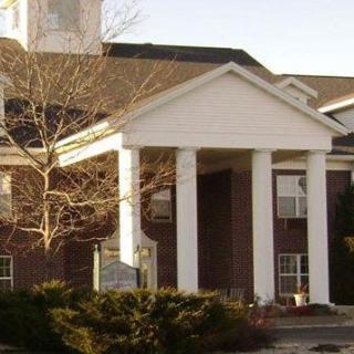 A brick building with white columns at the entrance.