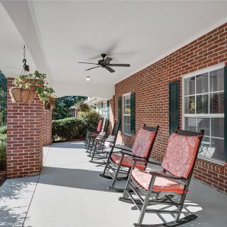 A cozy porch with rocking chairs and ceiling fans, providing a relaxing outdoor space.
