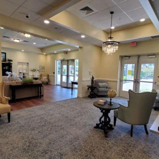 A spacious and elegantly decorated lobby with comfortable seating, warm lighting, and a chandelier.
