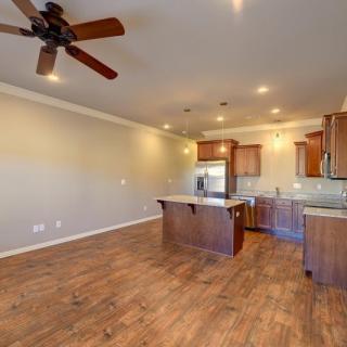 A spacious open floor plan combining kitchen and living area with hardwood floors and modern fixtures.