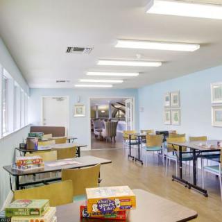 A classroom setting with tables and educational games arranged on the desks.
