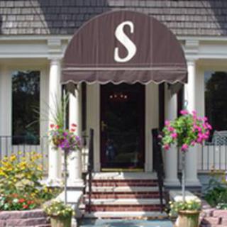 A welcoming entrance featuring a decorative awning and vibrant flowers.