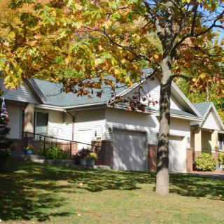 A suburban house surrounded by autumn foliage.