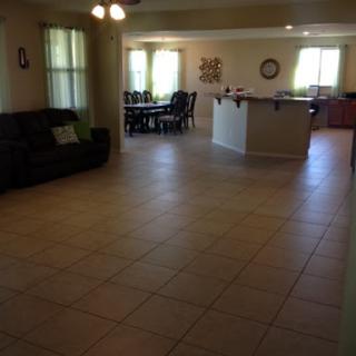 A spacious living room featuring a comfortable sofa with an adjoining dining area.