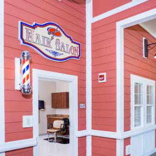 Entrance to a cozy barber shop featuring a classic barber pole and welcoming decor.