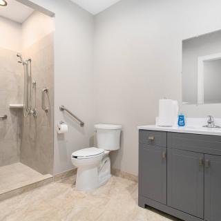 Modern bathroom with a walk-in shower, toilet, and vanity unit.