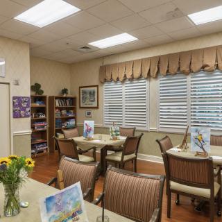 A cozy dining area with neatly arranged tables, chairs, and floral decorations.