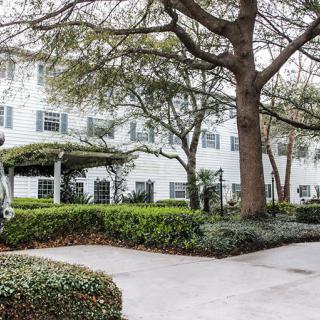 A residential building surrounded by lush trees and greenery.