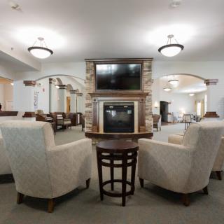 A modern lounge area with comfortable seating and a double-sided television setup.