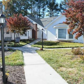 A quiet suburban neighborhood with houses and a well-maintained pathway.