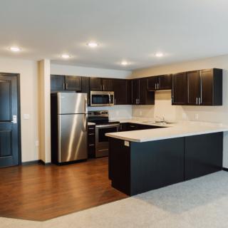 A modern kitchen with stainless steel appliances and dark cabinetry.