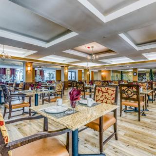 Spacious and elegantly designed restaurant interior with neatly arranged tables and chairs.