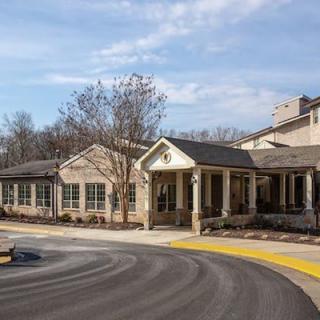 A large residential building with a welcoming entrance and surrounding trees.