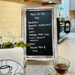 A chalkboard menu displaying the day's meals and drinks in a cozy cafe setting.