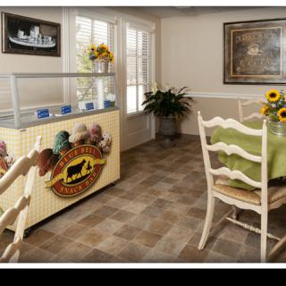 A cozy dining area with a sunflower-themed decor, featuring a table, chairs, and a display cabinet.
