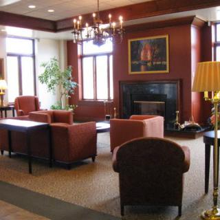 A cozy and elegant lobby area featuring plush seating, a warm fireplace, and decorative lighting.