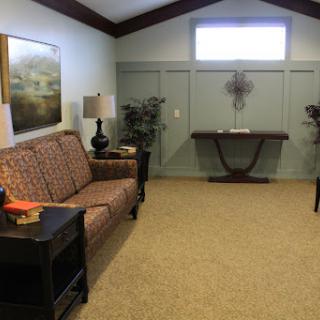 A cozy and inviting living room setup with a patterned sofa, side tables, and decorative plants.